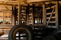 Aged house with geometric beams on ceiling and worn out tire on floor in sunlight