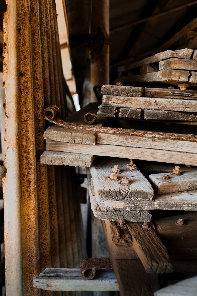 Lumber Near Rusty Fence In Warehouse In Countryside