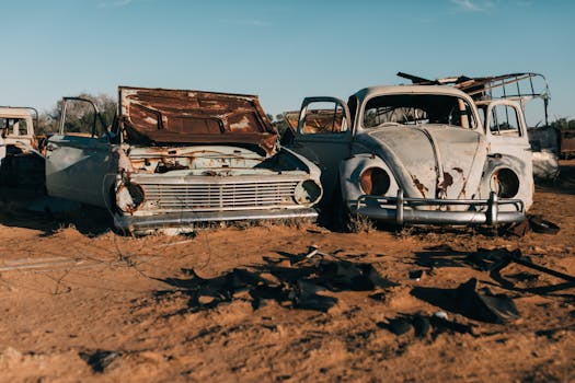 蔚蓝的天空下，一辆生锈的旧古董车停在废弃的垃圾场里