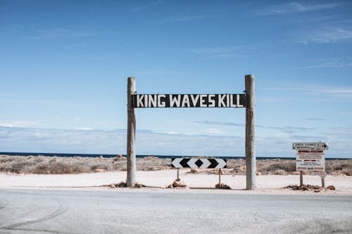 Inscriptions and road sign against sea in daytime