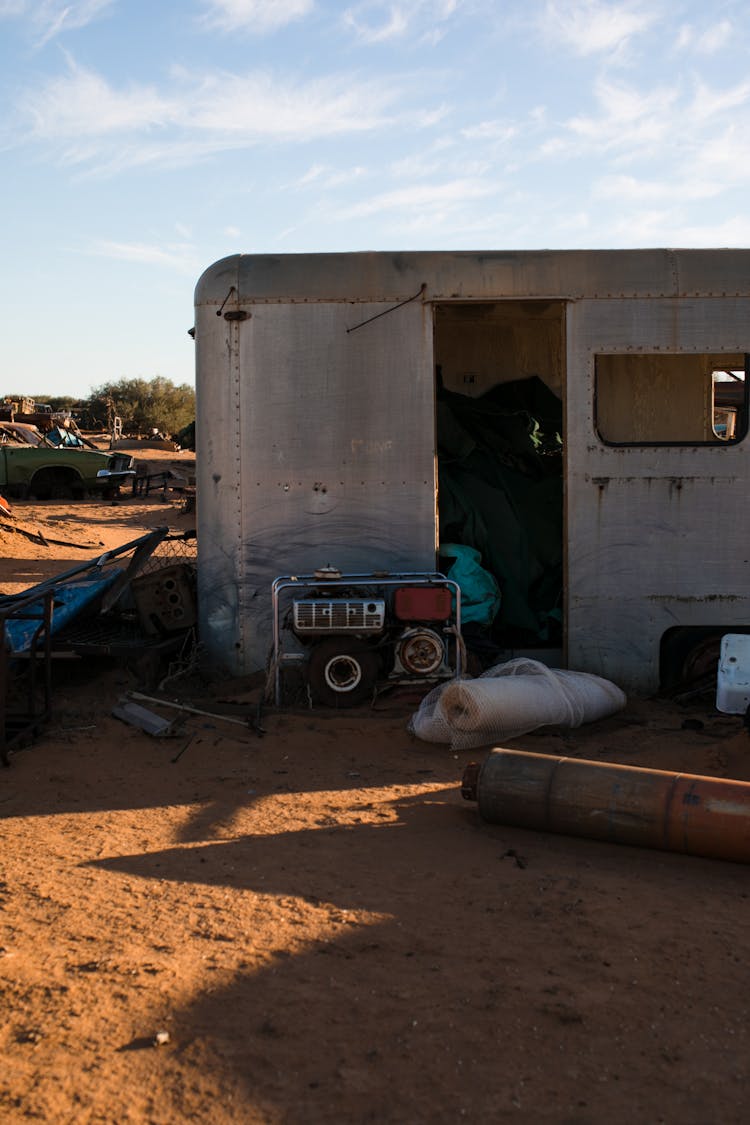 Old Trailer In Desert Under Cloudy Sky