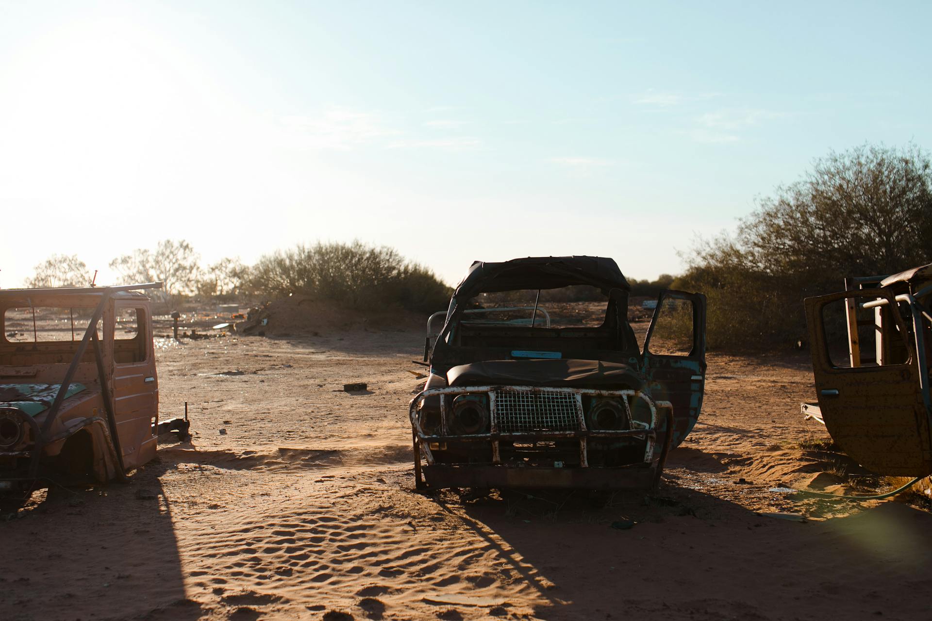 Rusty broken cars placed on sand