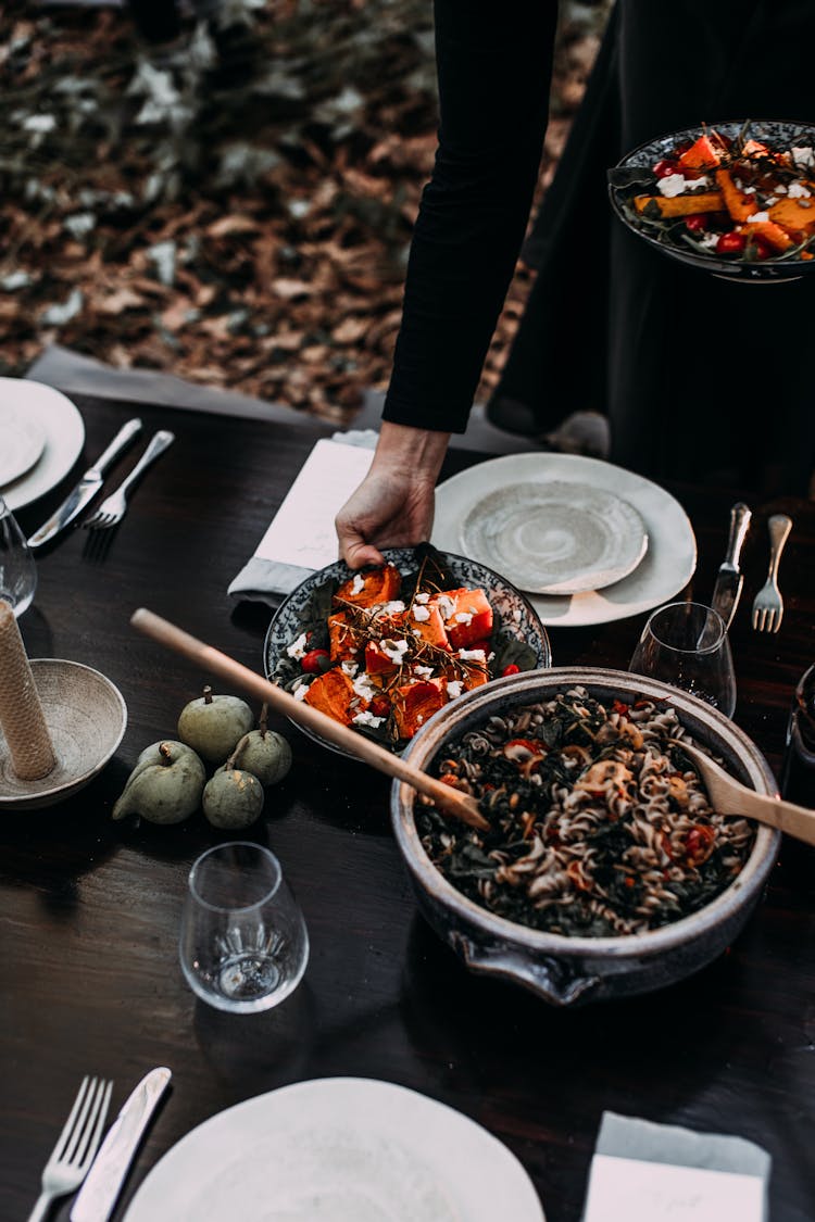 Woman Serving Table With Dishes For Picnic