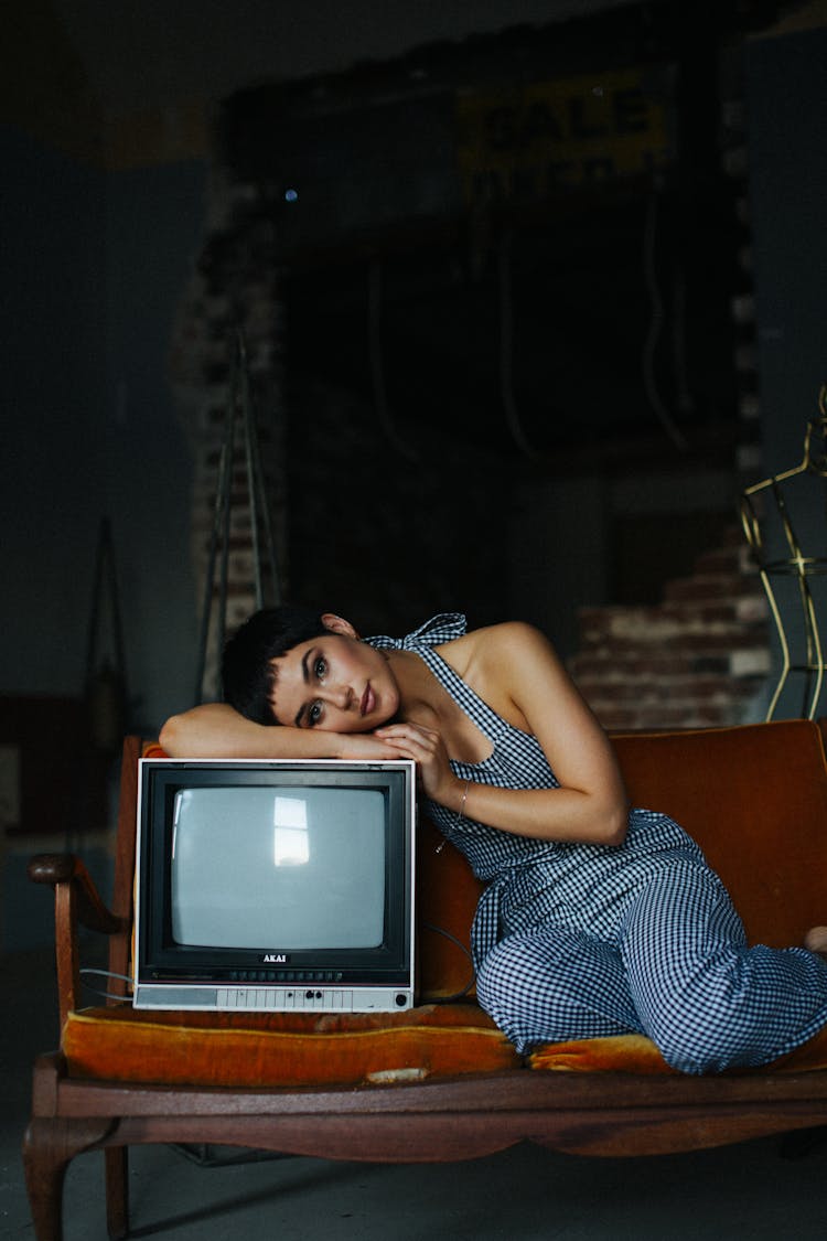 Shorthaired Woman Leaning On Retro TV Set In Studio