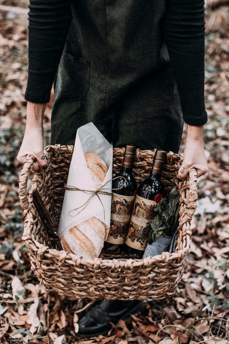 Person Carrying Basket With Fresh Bread And Wine