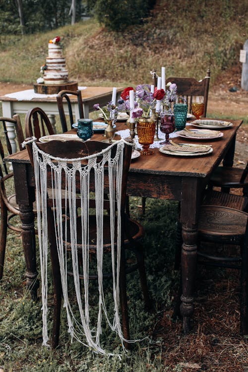 Festive wooden table and chairs placed in nature in daytime