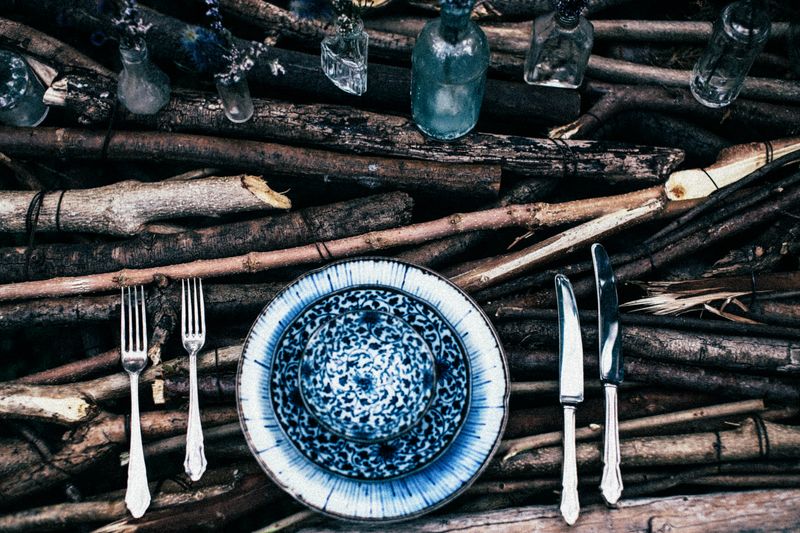 Boho table setting with stoneware, wooden board and natural tableware details