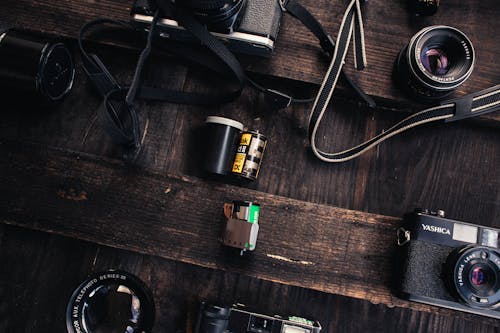 Free Vintage camera near lens and camera roll on table Stock Photo