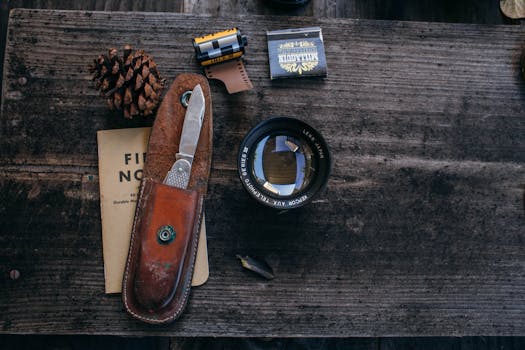 A creative arrangement of a knife, camera lens, and film on a rustic table.