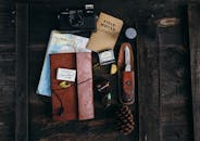 Retro camera near notepad and knife near map on desk