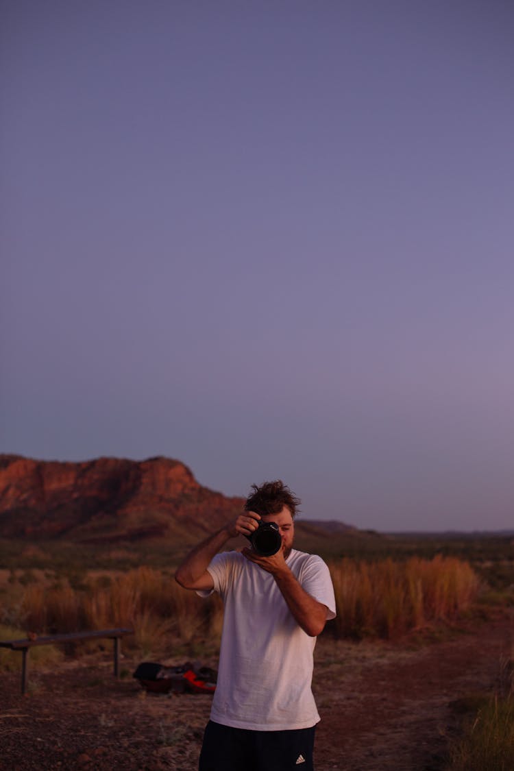 Faceless Male Photographer Taking Picture On Camera In Desert