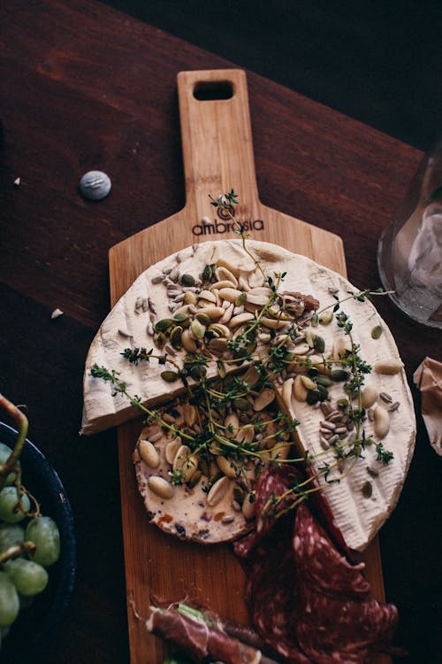 Delicious camembert cheese with meat on wooden board