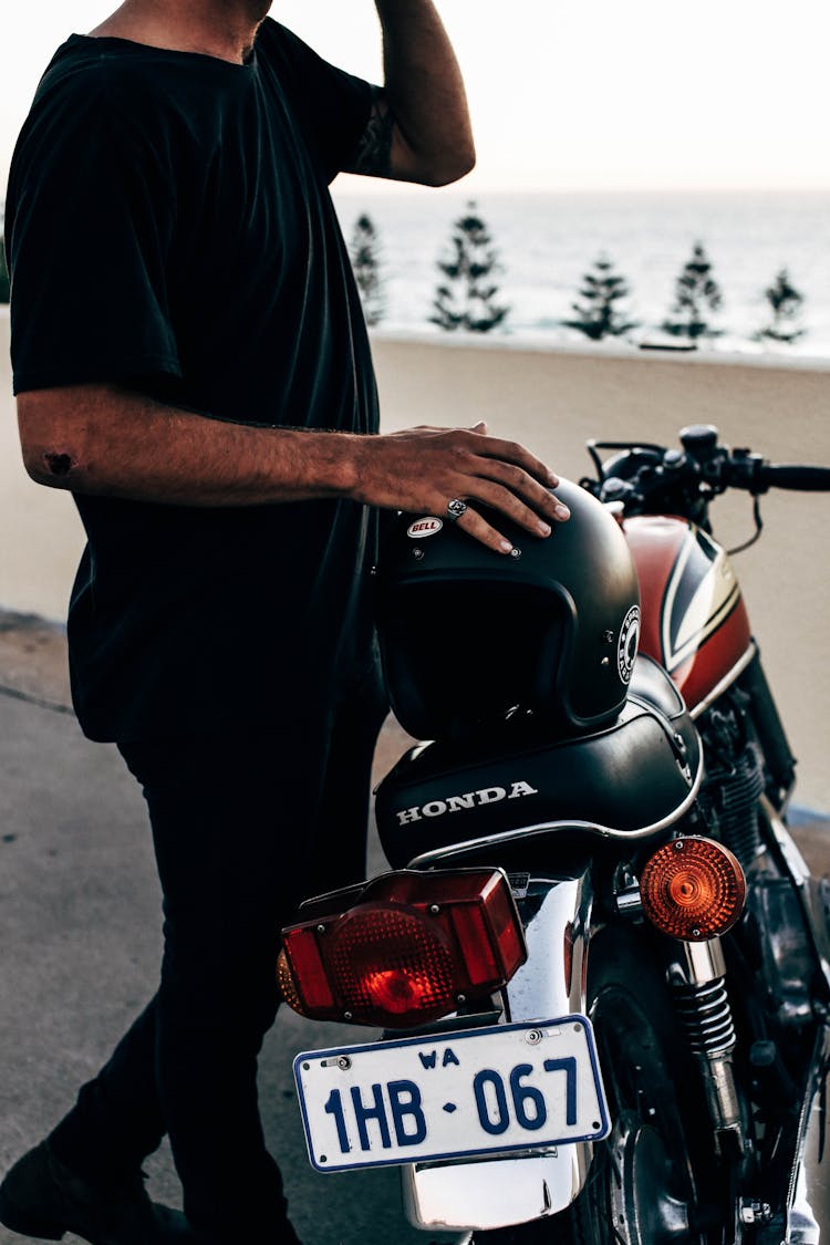 Ethnic Man Standing Near Motorcycle