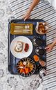 Tray with food and drinks on bed