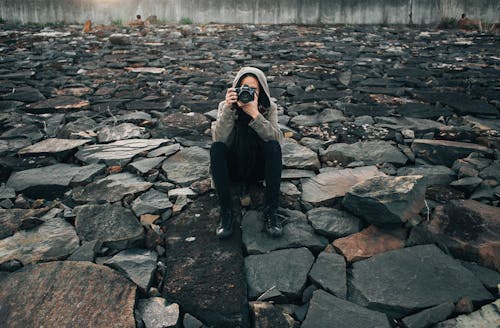 Concentrated photographer taking picture on stones