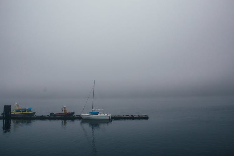 Boats Moored On Quay In Calm Water