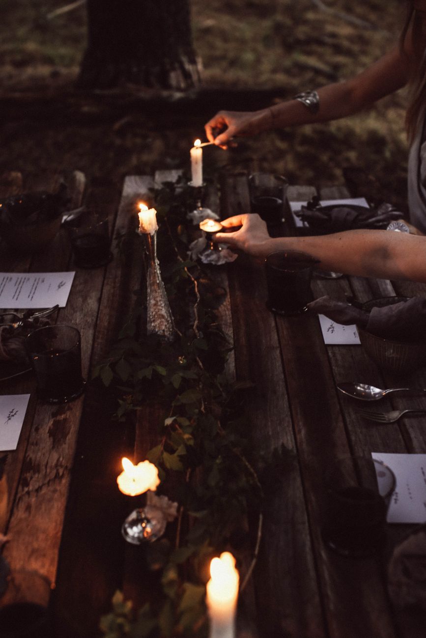 long candlelit outdoor dinner table at dusk
