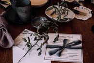 Wedding invitation on table with utensil and decorations