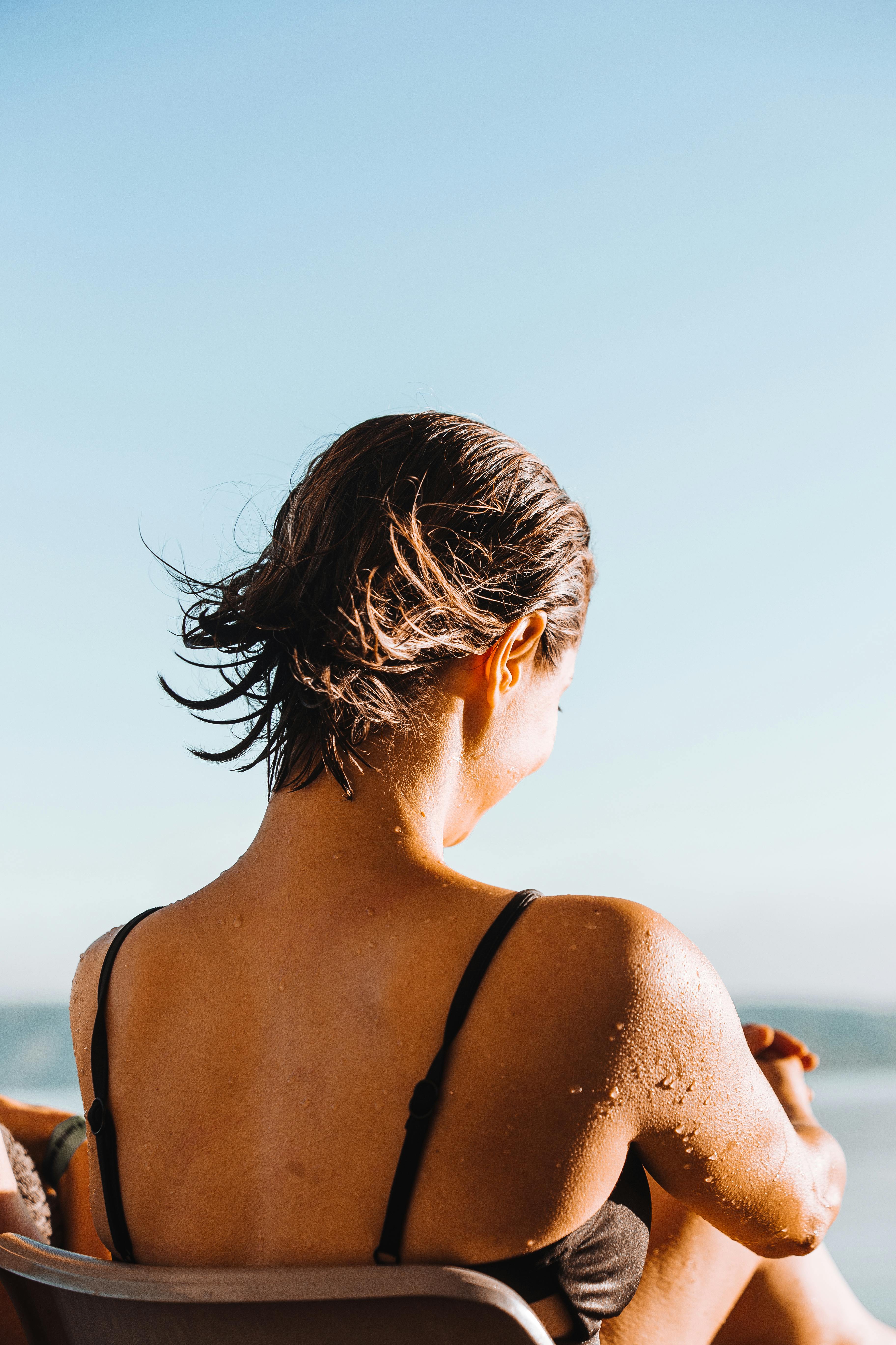 woman with short flying hair on sunny beach