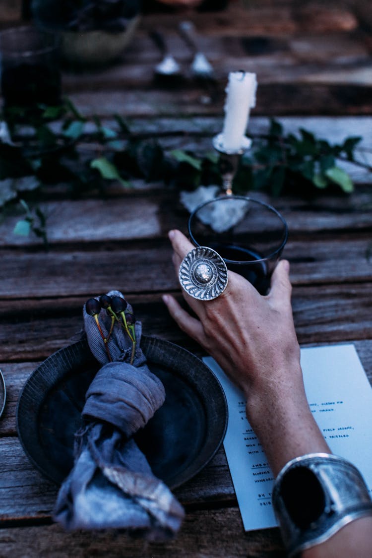 Person With Vintage Ring And Glass Of Wine At Table