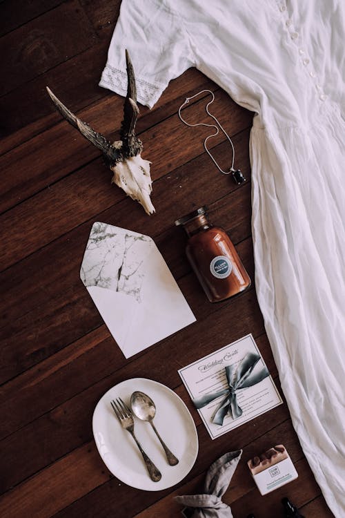 Top view of vintage greeting card and envelope placed near utensil and white dress