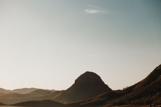 明亮的天空映衬着宁静的山脉景色，是自然主题的理想选择