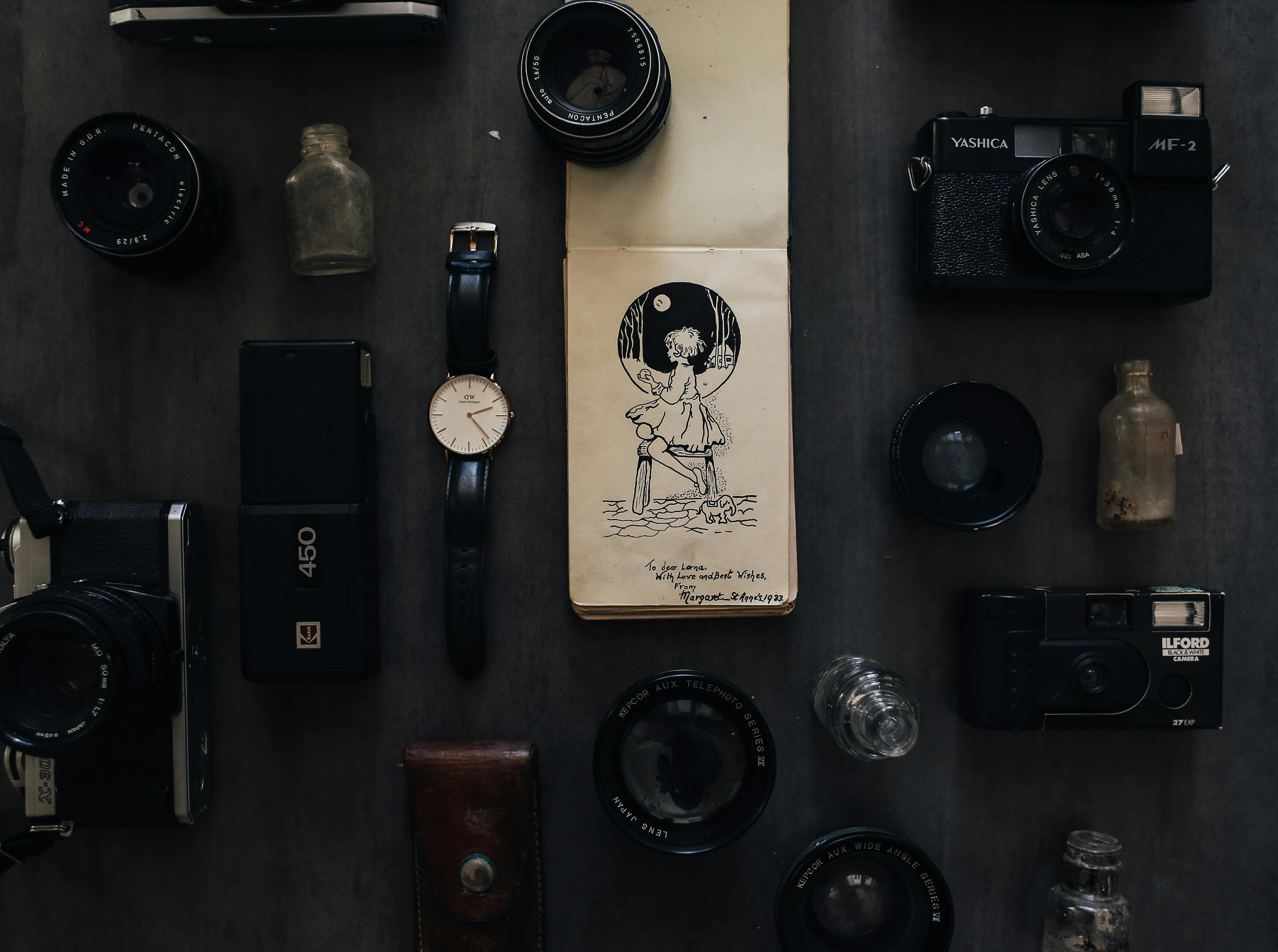 vintage notebook among photo cameras with lenses