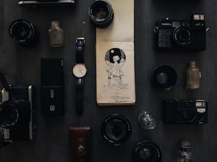 Vintage notebook among photo cameras with lenses