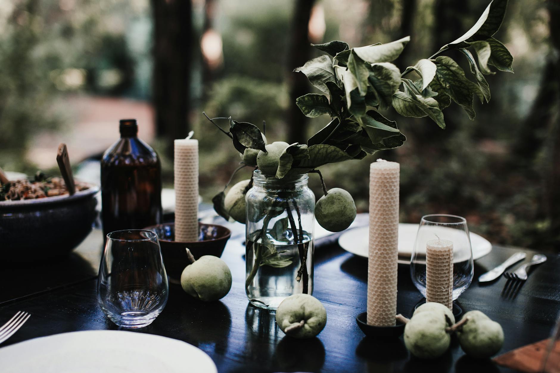 Candles with fresh apples placed on table
