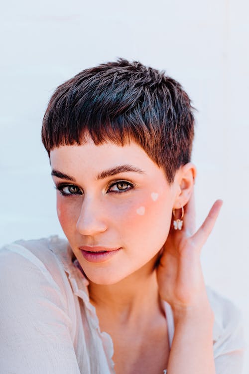 Stylish woman with short hair touching neck