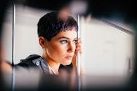 Fashionable young woman holding handrail and looking away thoughtfully