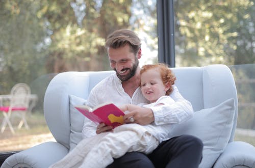 A Father Reading a Book to His Kid 