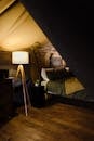 Comfortable forged bed with nightstand and lamp placed in cozy tent house at campsite