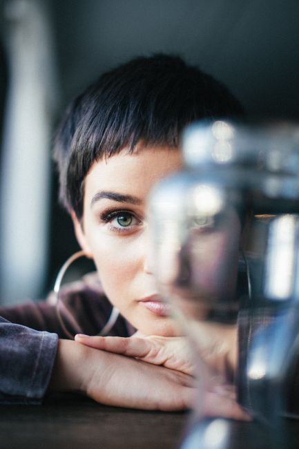 Artistic portrait of a woman with short hair and hoop earrings gazing confidently.