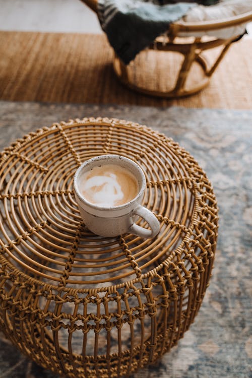 Free From above of cup of latte placed on wicker table on carpet in apartment in morning Stock Photo