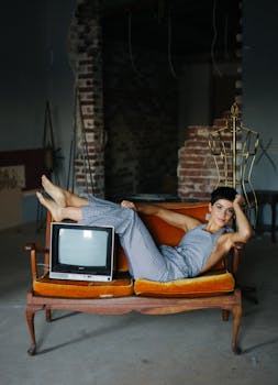 在乡村环境中，一位时尚的女人在老式沙发上摆姿势，旁边配有一台旧电视