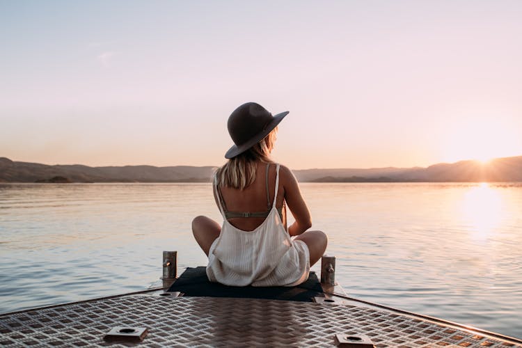 Woman In Hat Enjoying Sunset On Pier