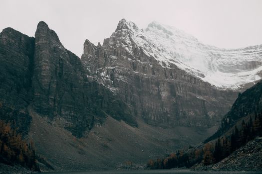在多云的天空下，风景如画的落基山脉陡峭而覆雪