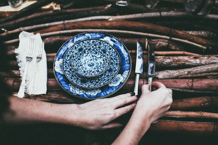 Crop Woman Serving Cutlery On Table