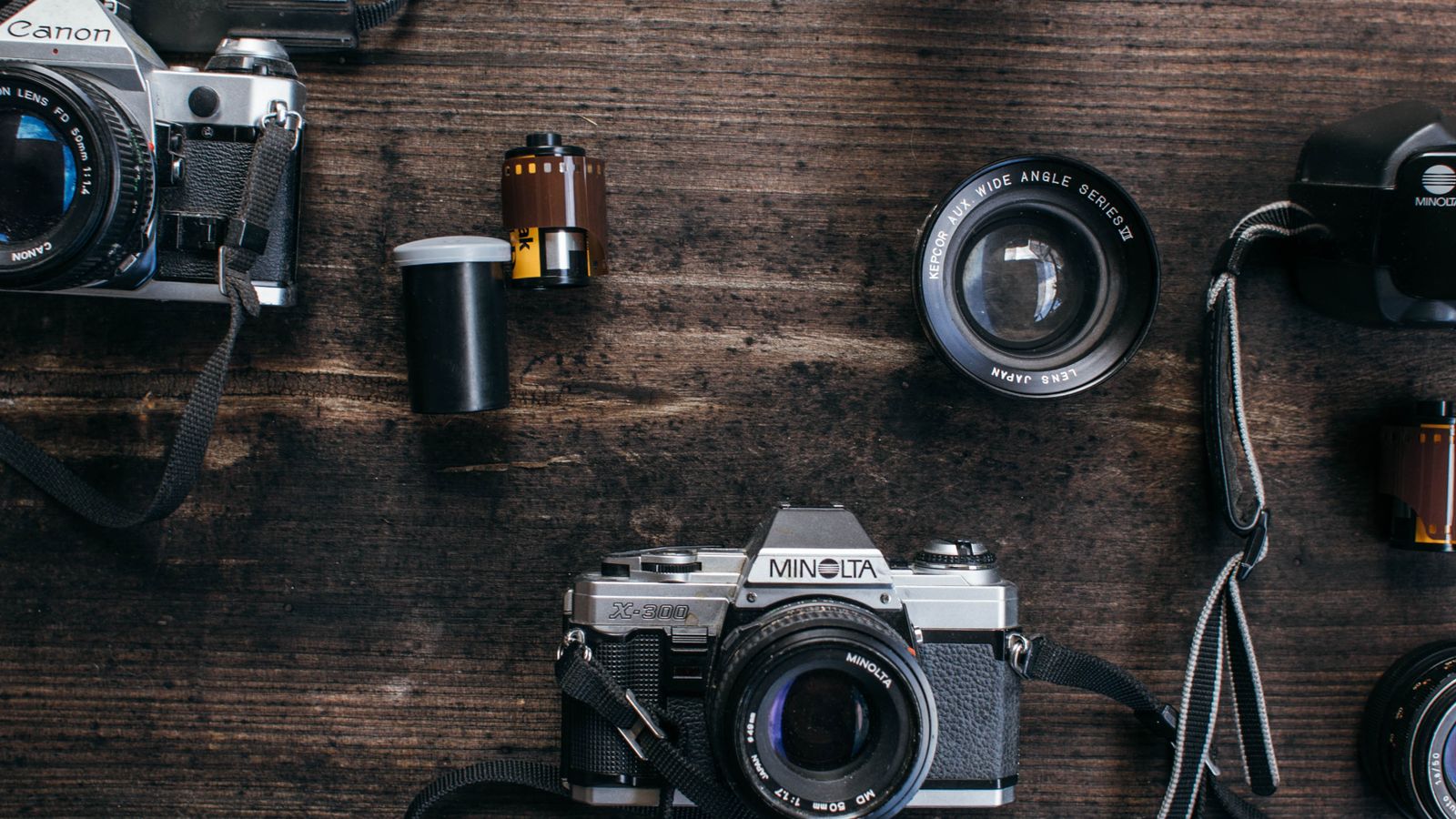 Film cameras and lenses arranged on a wooden table