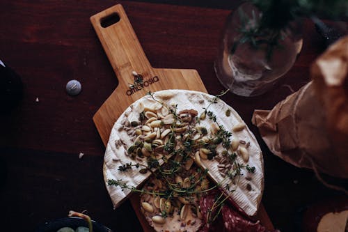 Delicious cheese and sausage garnished with nuts and herbs in restaurant