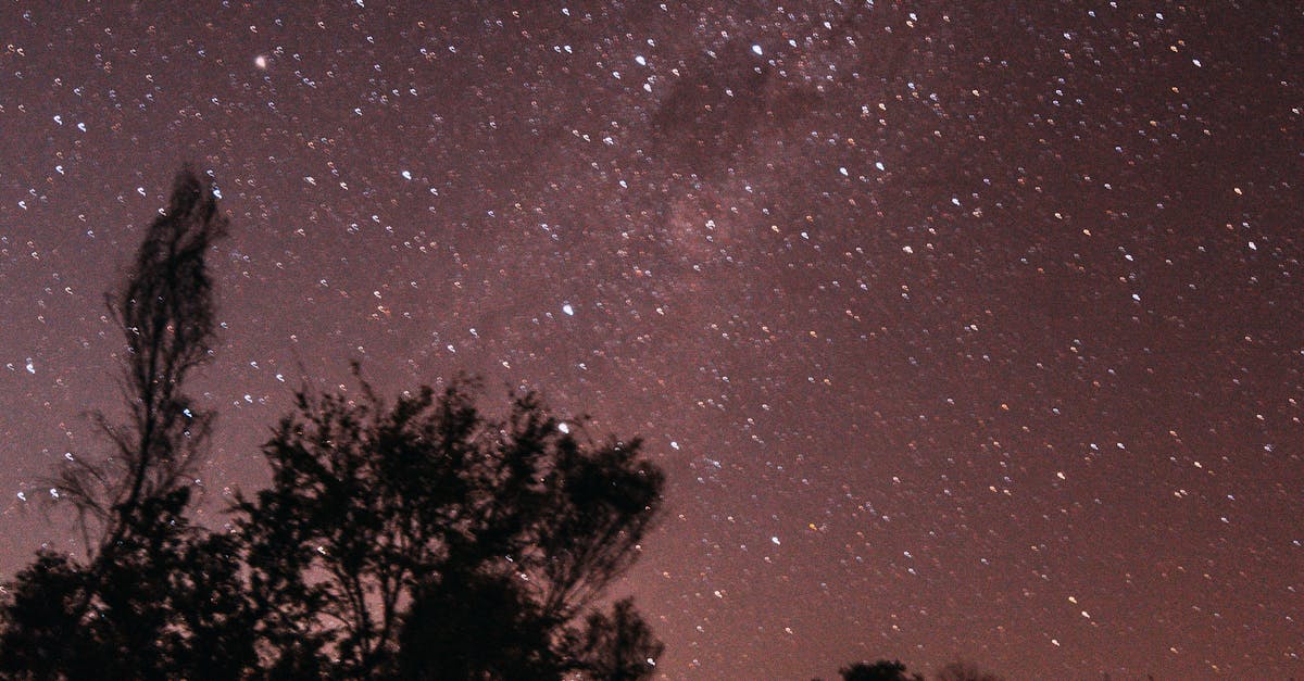 Anonymous camper in tent against starry sky