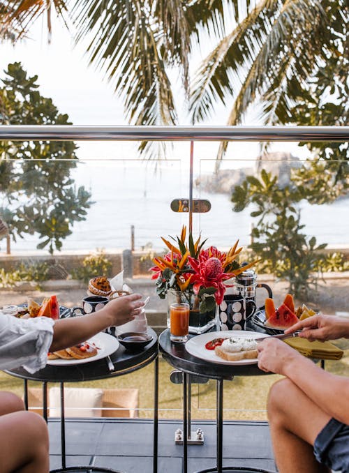 Free Unrecognizable young couple having breakfast on terrace during romantic trip Stock Photo