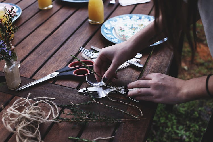 Unrecognizable Female Florist Decorating Dinner Table Before Event In Nature