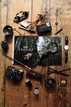 Flat lay of vintage photography gear and an open magazine on a rustic wooden table.