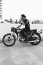Unrecognizable male biker riding motorcycle on asphalt road