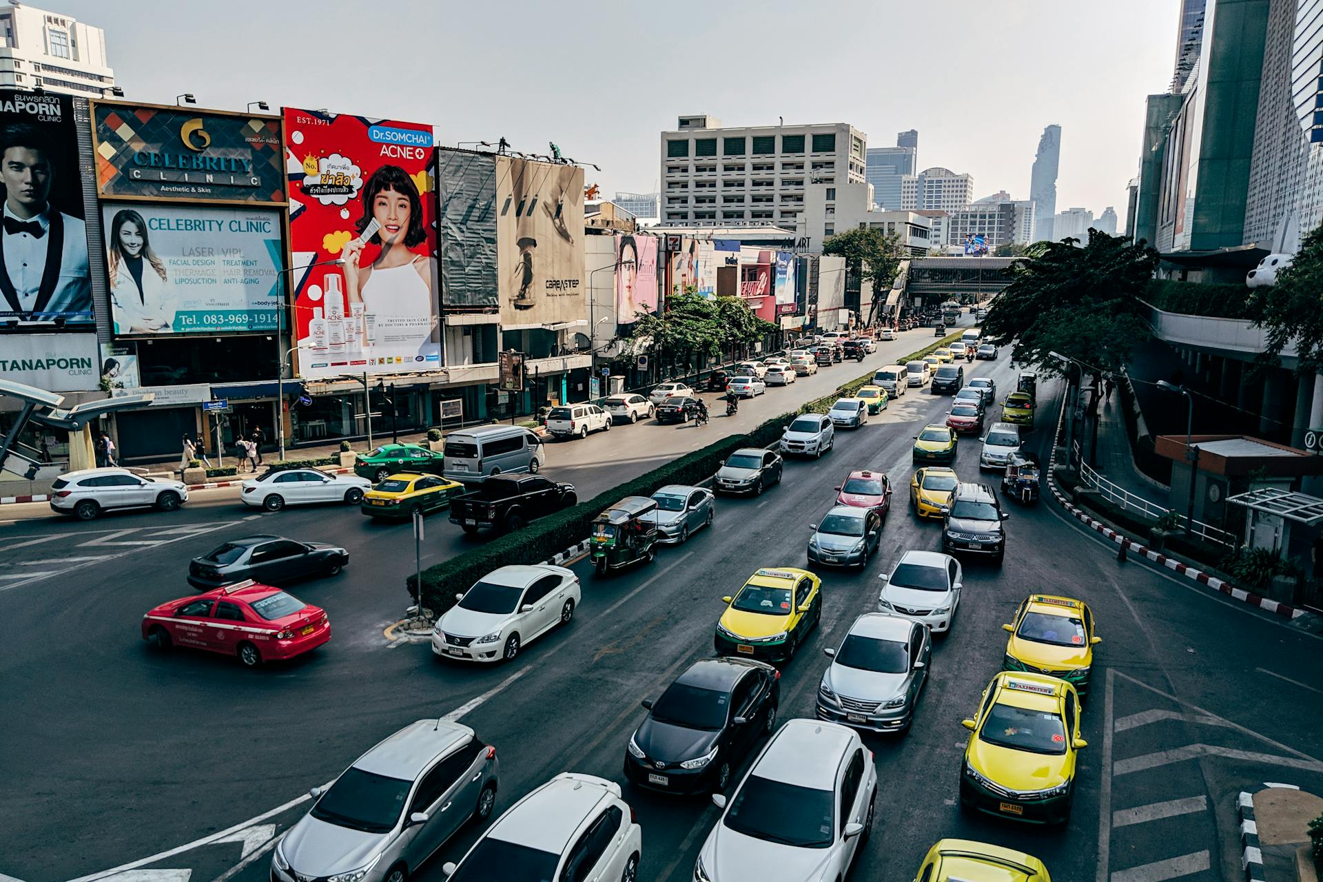 Busy traffic scene in downtown Bangkok, Thailand with cars and billboards.