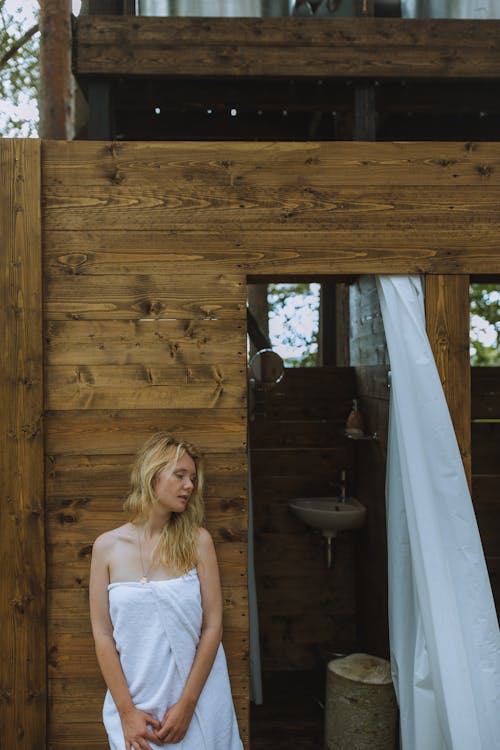 Woman in White Bath Towel Standing Beside a Wooden Shower Room
