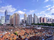 Aerial View of Town with Houses Next to High Rise City Buildings Under Blue Sky