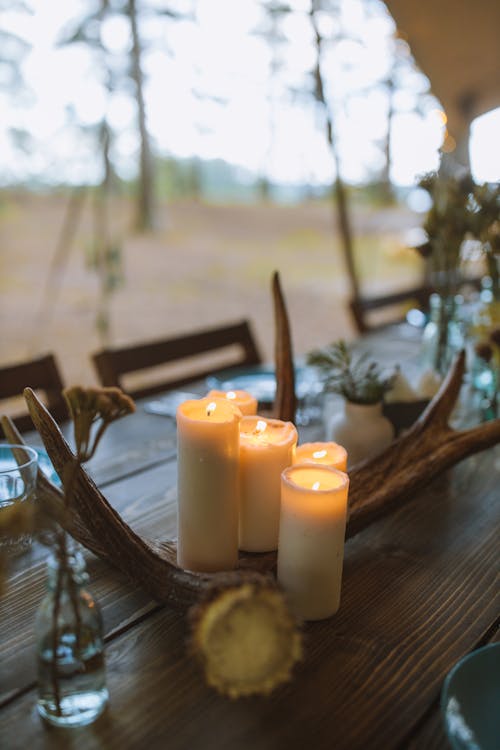 Free White Pillar Candles on Brown Wooden Table Stock Photo